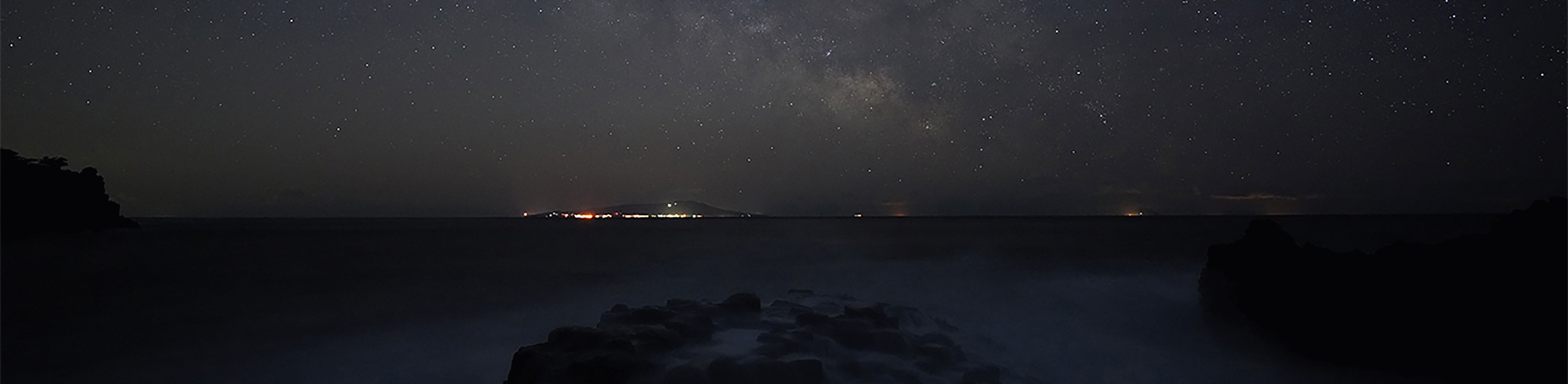 Foto van sterrenhemel boven de zee met de Melkweg