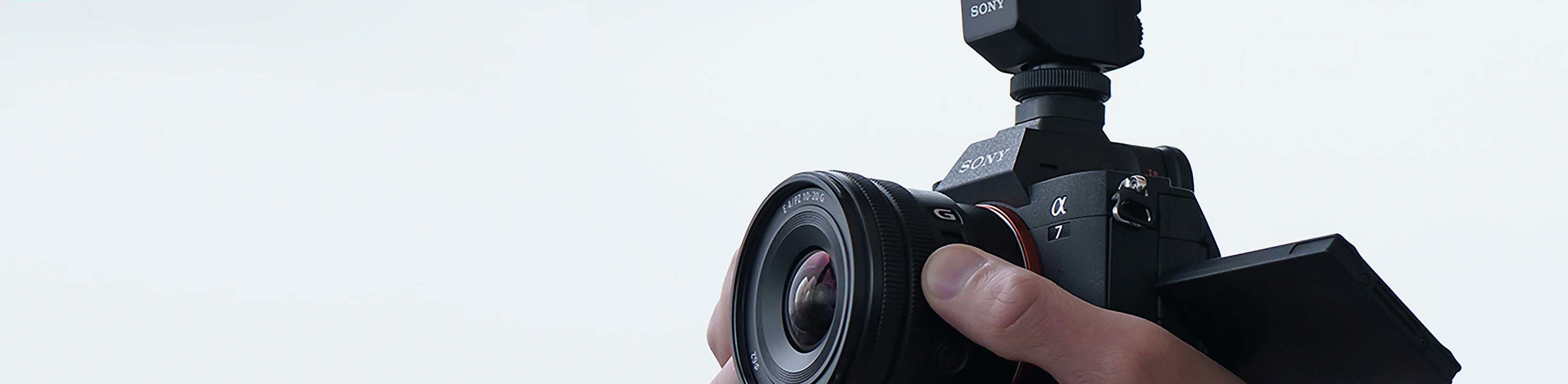 Bild eines Mannes beim Aufnehmen eines Videoclips und Bedienen des Zoom-Hebels des E PZ 10–20 mm F4 G