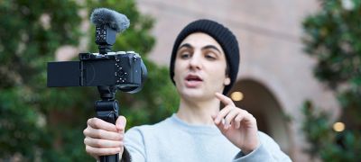 Obrázok osoby, ktorá fotí selfie v supersmerovom režime s mikrofónom ECM-B10 pripojeným ku kamere.