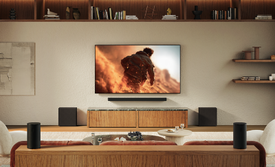 Salon avec un téléviseur, une barre de son et plusieurs caissons de basses placés autour des places assises