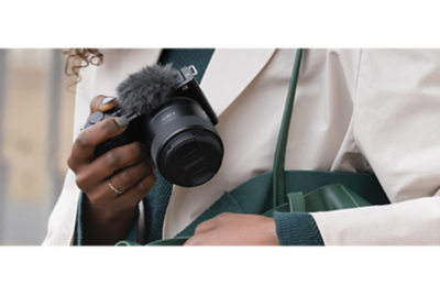 Modelo sacando una cámara de un bolso