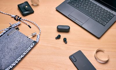 You can see the WF-C510 earbuds on a desk with other desk accessories such as a laptop, phone and pens.