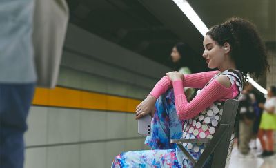 A young woman wearing LinkBuds Fit waiting for a train.