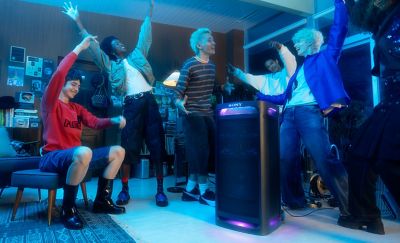 Un grupo de personas alrededor del parlante TOWER 9AC bailando en una habitación.