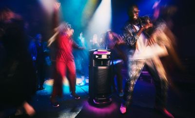 Gente bailando en un club nocturno con el parlante ULT TOWER 10 reproduciendo música.