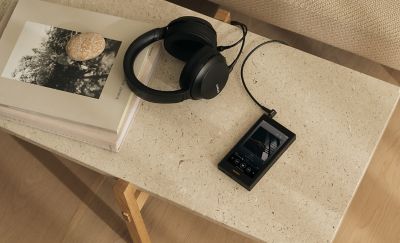 Sony NW‑ZX900 and Sony headphones laid on a textured stone side table