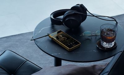 Lifestyle shot, NW‑WM1ZM3 paired with headphones on side table
