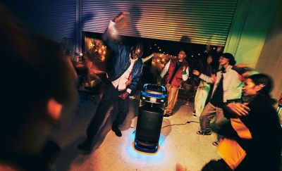People at a house party with the ULT TOWER 10 speaker providing the music. 