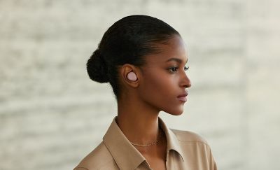 A person facing to the right with a pink ear bud in their ear
