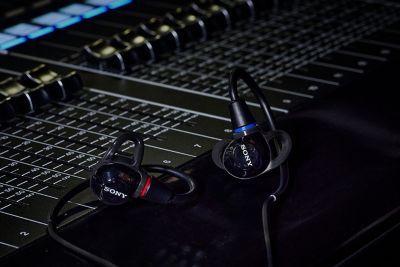 Audífonos Sony negros colocados sobre una consola de mezcla