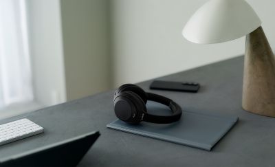Căști Sony WH-1000XM4C, modelul negru, pe un birou minimalist acasă