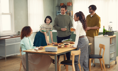 Image de cinq personnes dans une salle à manger, entourées des trois enceintes HT-AX7