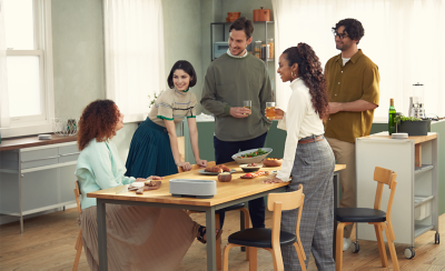 Image of five people in a dining room surrounded by the three HT-AX7 speakers