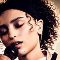 Persona que canta al micrófono con unos audífonos Sony transparentes