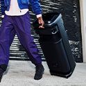 A young person transporting the ULT TOWER 10 speaker by pulling it behind them.