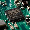 Close up of the ESS DAC chip on a motherboard with various other components.