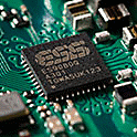 Close up of the ESS DAC chip on a motherboard with various other components.
