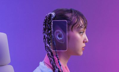 A gamer with a phone over their ear and a representation of an ear on-screen