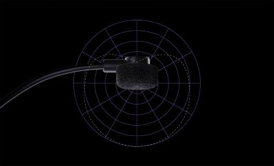 Primer plano de un micrófono negro sobre un fondo negro y morado