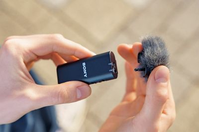 Image of person placing the supplied windscreen onto the ECM-W2BT