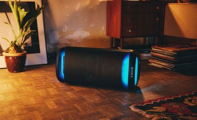 An SRS-XV500 speaker lying horizontally in a relaxed bedroom setting