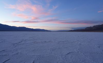 Captura gran angular de un paisaje desértico con una puesta de sol detrás de unas montañas distantes