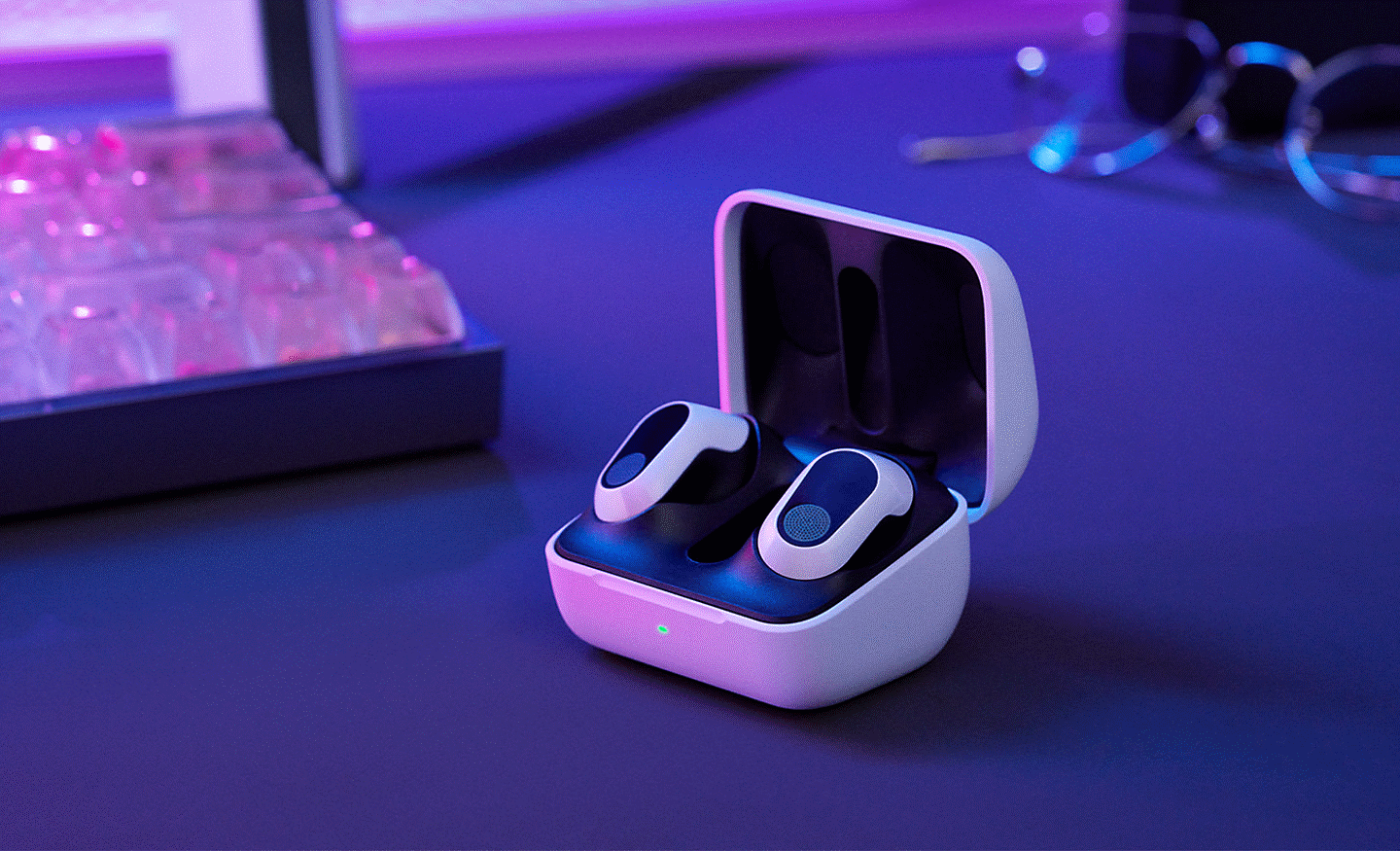 The INZONE Buds in the charging case on a desk with a keyboard