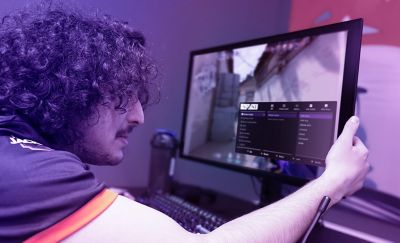 Un membro del team FNATIC esamina attentamente i dati di un gioco sul nuovo monitor da gaming M10S