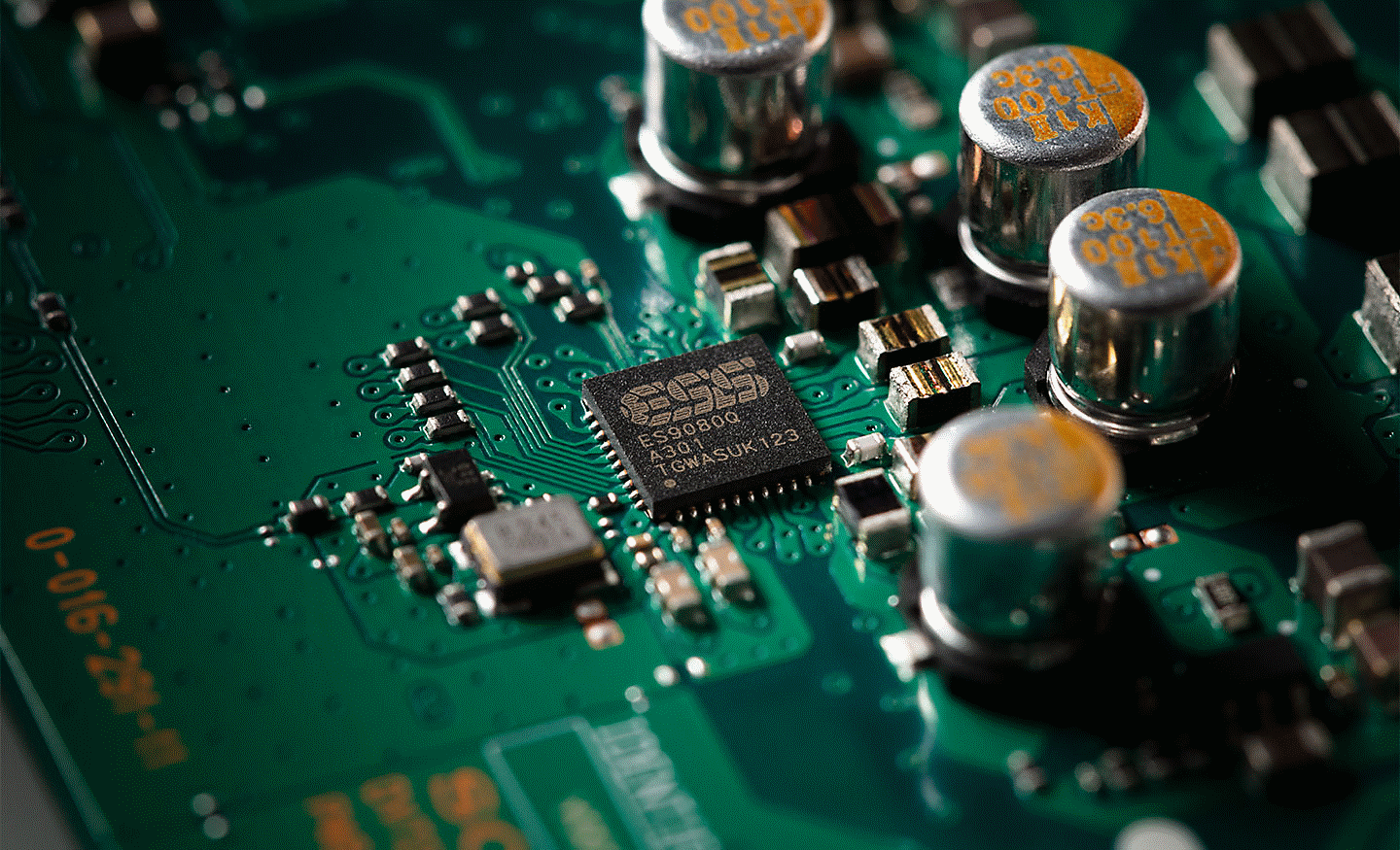 Gambar close-up chip ESS DAC pada motherboard dengan berbagai komponen lainnya.