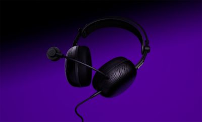 Audífonos tipo diadema negros con micrófono sobre un fondo morado