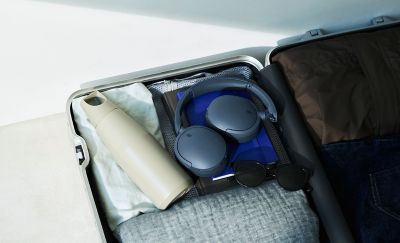 Složená modrá sluchátka Sony WH-CH730N zabalená v otevřeném cestovním kufru