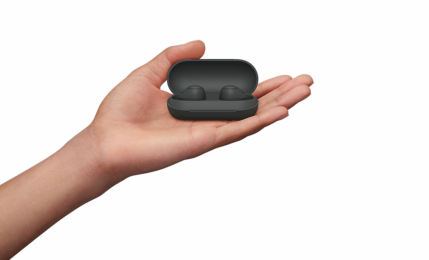 Gambar tangan yang memegang sepasang Noise Cancelling Headphone Nirkabel WF-C700N warna hitam dalam casingnya