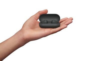 圖中一隻手拿著裝在保護殼裡的一對黑色 WF-C700N 無線降噪耳機