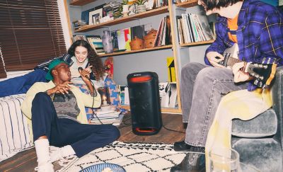 The SRS-XV500 speaker with both a guitar and a microphone plugged in, featuring people singing and playing