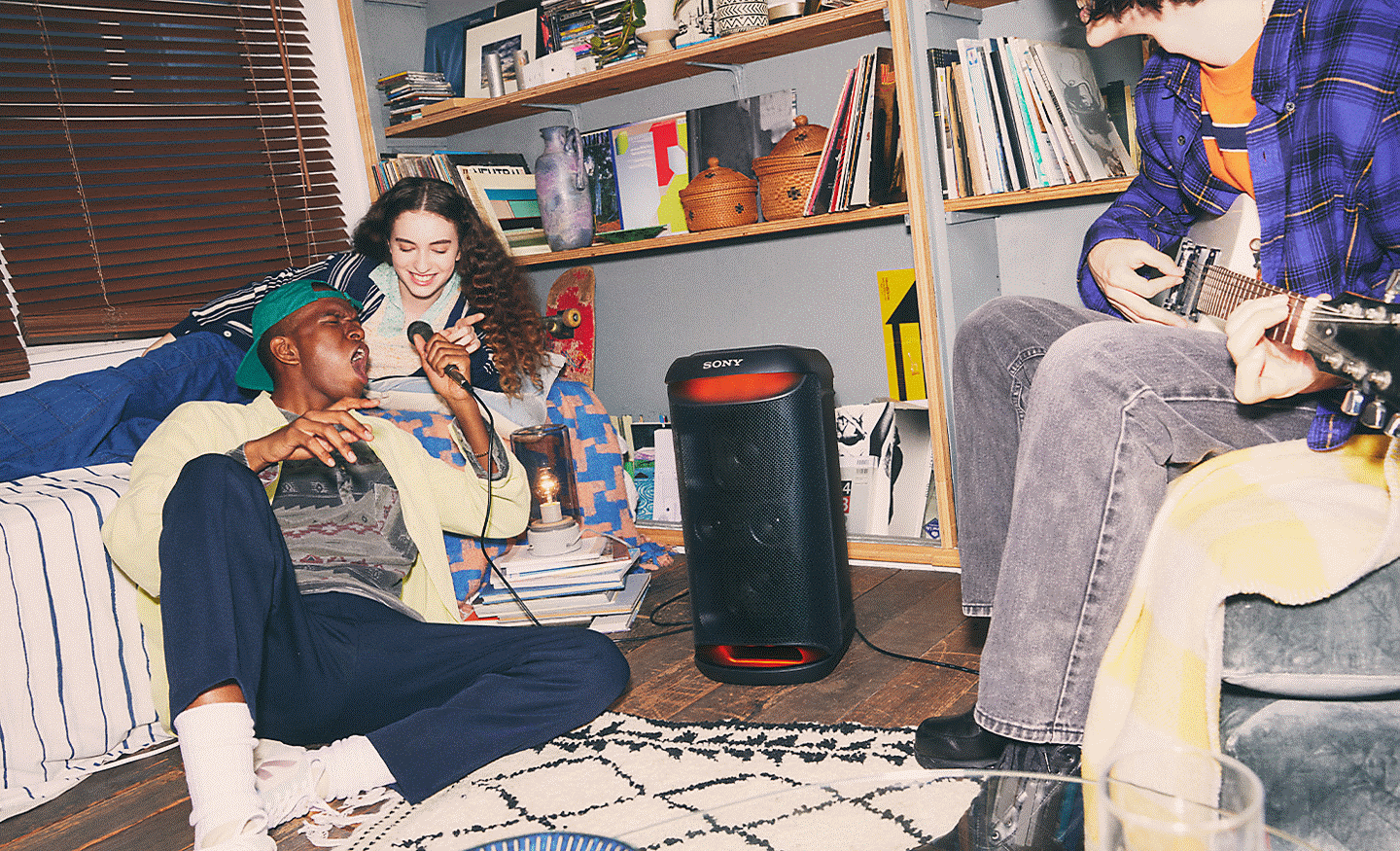 The SRS-XV500 speaker with both a guitar and a microphone plugged in, featuring people singing and playing
