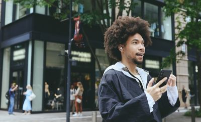 A young man wearing LinkBuds Open earbuds speaking on the phone.