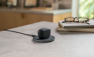 Image of WF-1000MX5 headphones on a wireless charging station on top of a desk