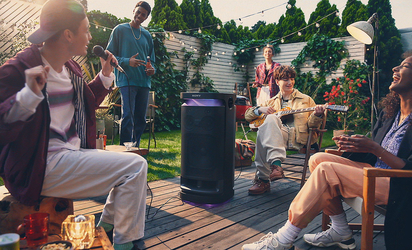 Kép emberekről, akik az SRS-XV900 vezeték nélküli hangsugárzó Karaoke és DJ funkcióját élvezik