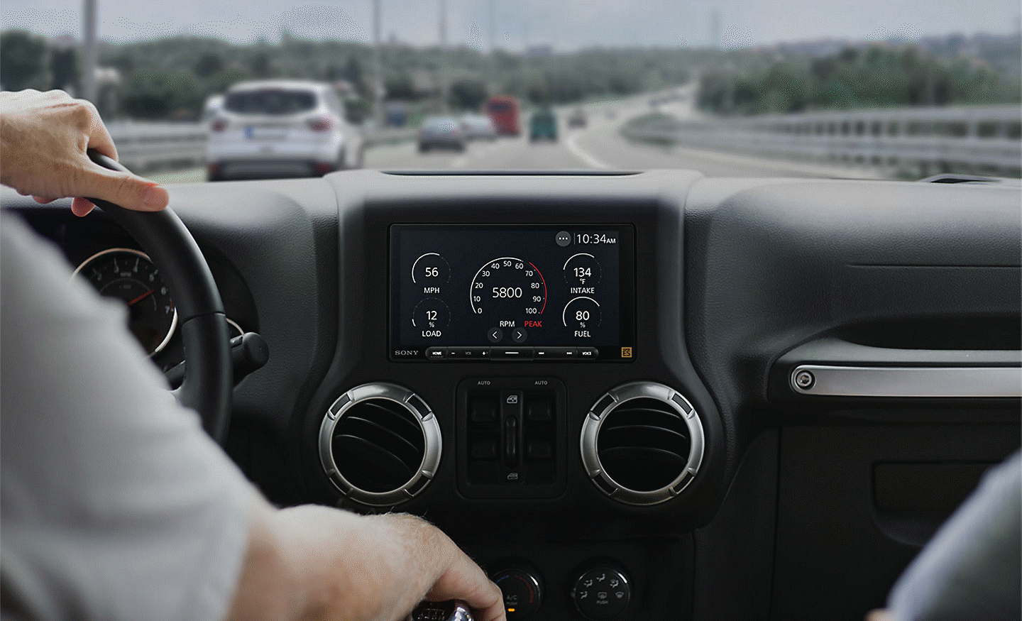 Vue de face d’une personne conduisant avec le récepteur multimédia XAV-9000ES affichant les données de conduite.