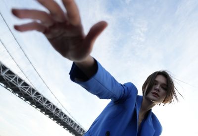 Retrato gran angular de una mujer con una parte de un puente colgante en el fondo