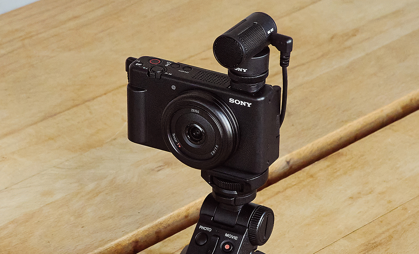 Слика од корисник кој снима автопортрет со фотоапарат и држач за снимање, го користи безжичниот микрофон ECM-W2BT