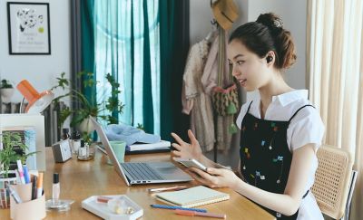 A young woman wearing a pair of LinkBuds Open earbuds taking a video call from her laptop.