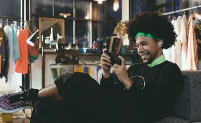 A young man wearing a pair of LinkBuds Open earbuds watching something on his phone.