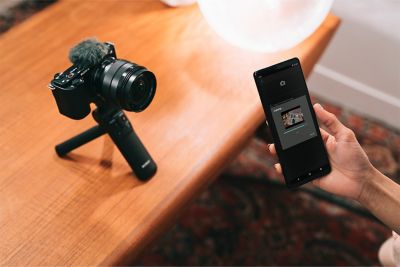 Ситуативное изображение человека, передающего ролик на смартфон с помощью Imaging Edge Mobile