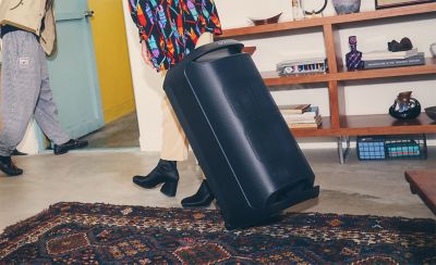 Image of the SRS-V800 being moved from a room by tilting it back onto its wheels and holding the handle