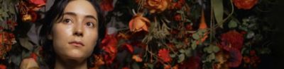 Image of a woman with flowers in the background