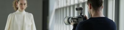Image of a man shooting a movie with a woman as the subject of the shot