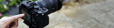 Photo of a person holding the camera and using its buttons