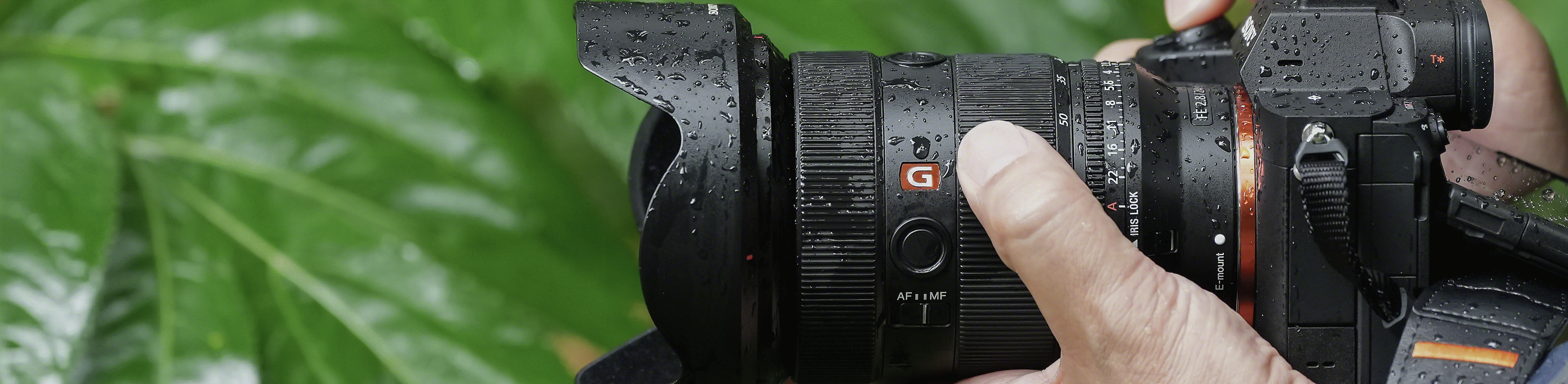 Kuva miehestä pitelemässä α7R V -kameraa, jonka pinta on märkä