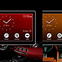 Image of two XAV-AX4050s each with clocks and coloured backgrounds on-screen